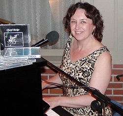 Cheryl Hodge at the piano, next to her first CD, entitled "Tonight I'm Wearing Basic Black"